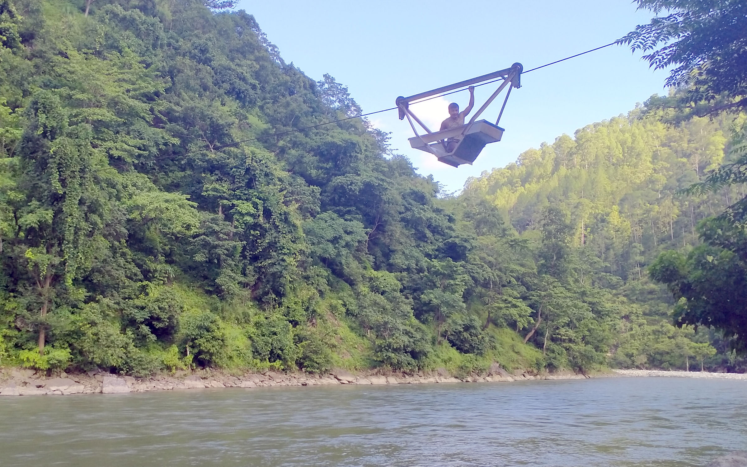 तुइनको सहायताबाट नदी तर्दै